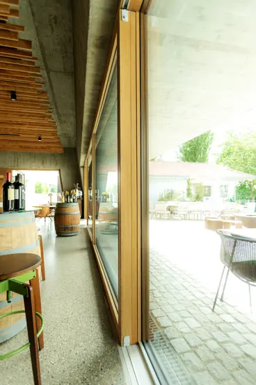 Perspektivische Ansicht entlang der XXXL-Glasfront im Restaurant Hofgut Hafnerleiten. Panoramafenster in Maximalgröße, gefertigt durch die Schreinerei Renaltner (seit 1926).