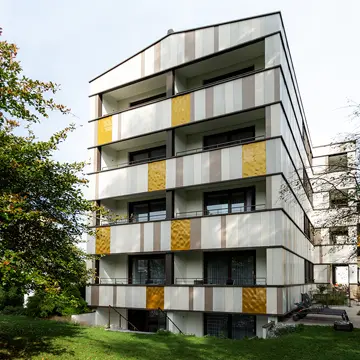 Idyllische Gartenansicht der Balkon-Sonderverglasungen und Keramikfassade in Bad Füssing: Hochwertiger Fensterbau der Schreinerei Franz Renaltner für Kunden in Niederbayern, Passau und München.