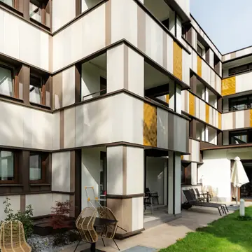 Innenhof-Ansicht mit moderner Fenster-Sonderverglasung und Keramikfassade in Bad Füssing: Hochwertiger Fensterbau der Schreinerei Franz Renaltner für anspruchsvolle Projekte in Niederbayern und München.