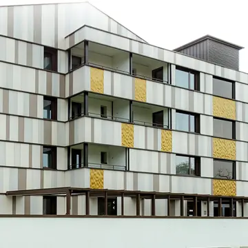 Detailreiche Seitenansicht maßgefertigter Fenster und Keramikfassaden-Elemente in Bad Füssing: Handwerksqualität der Schreinerei Franz Renaltner, Spezialist für Fensterlösungen in Niederbayern und München.