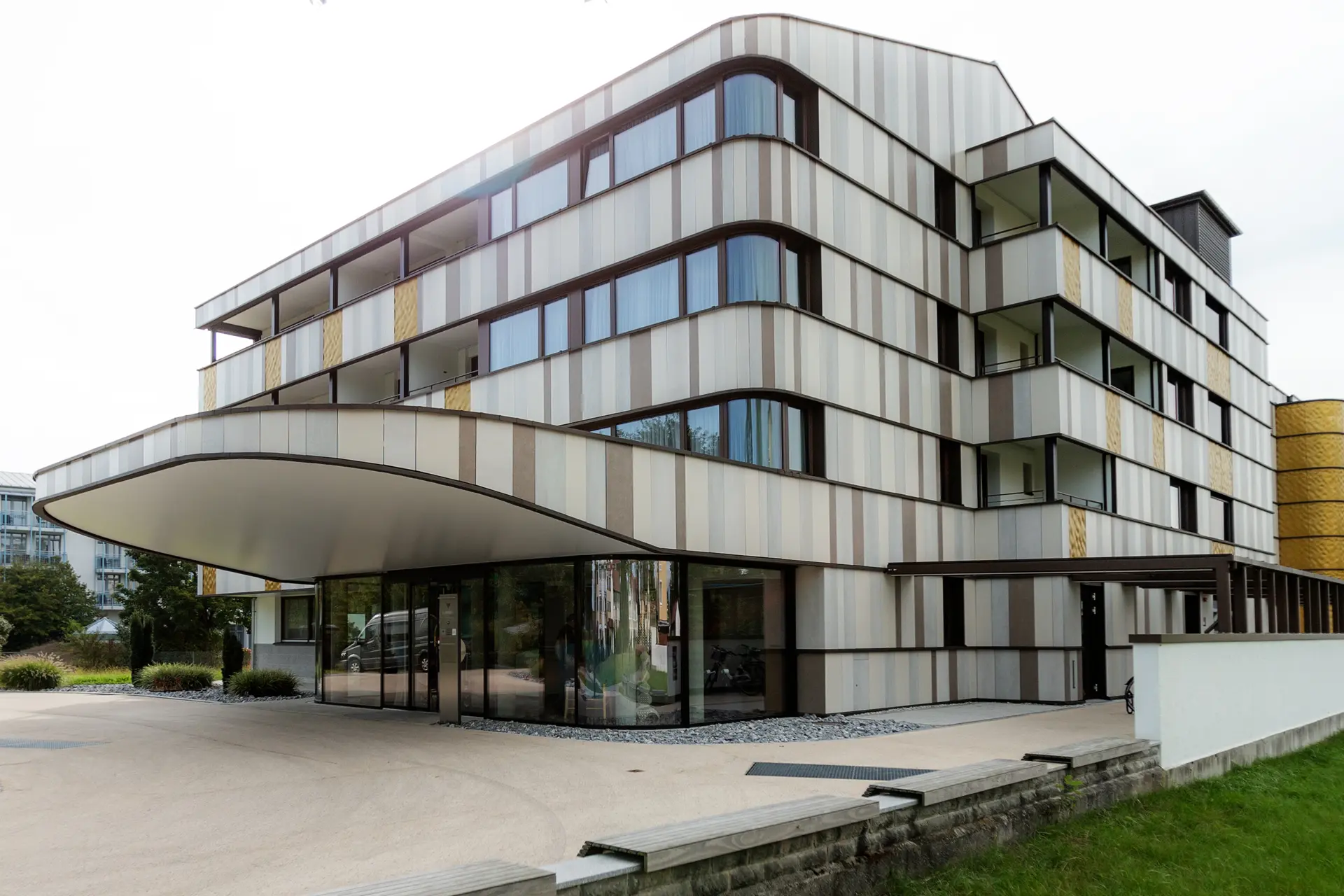 Exklusive Fassadengestaltung am Thermalresort Köck in Bad Füssing: Maßgefertigte geschwungene Gläser an den Balkonfenstern – höchste Präzision von Schreinerei Renaltner.