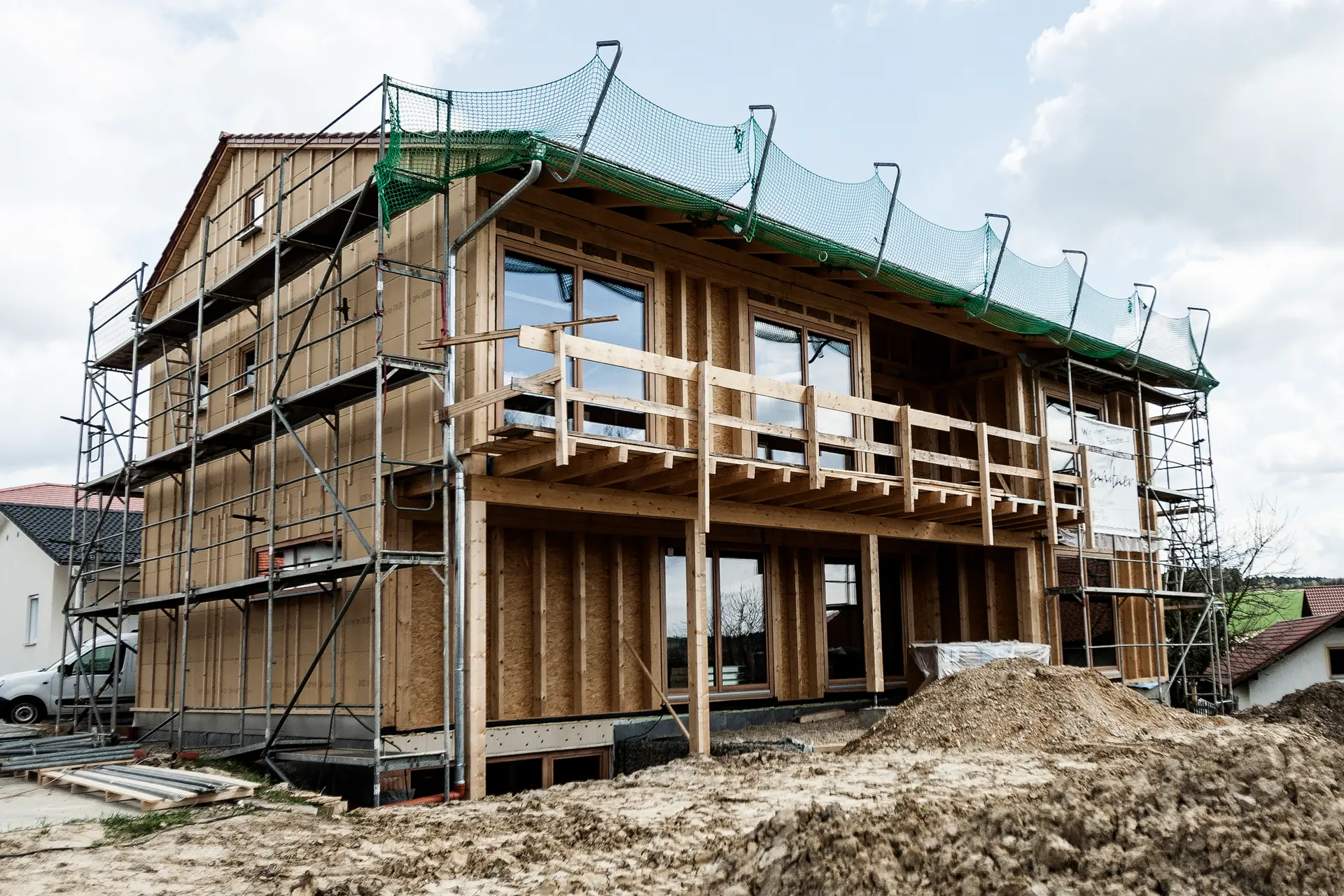 Maßgefertigte Holzfenster in Lärche von Renaltner, perfekt integriert in die Fassade eines Vollholzhauses – gefertigt in Zusammenarbeit mit der Zimmerei Pilsl.