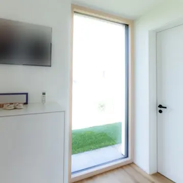 Panorama-Verglasung im Kinderzimmer eines modernen Bungalows in Fürstenzell. Maßgefertigte Fensterfronten der Schreinerei Franz Renaltner – Experte für großflächige Fenster in Passau und München.