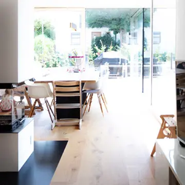 Wohnbereich mit Kamin-Sichtglas und Panoramablick durch XXXL Fenster in Fürstenzell. Gefertigt von der Schreinerei Franz Renaltner, Fenster-Spezialist für Passau, Niederbayern und München.