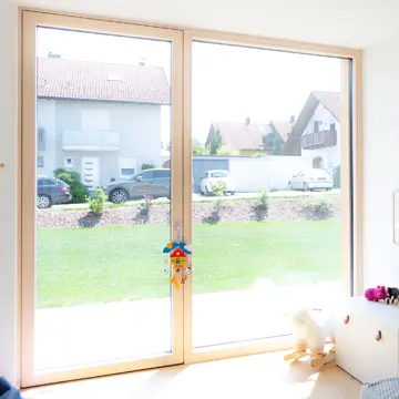 Bungalow-Kinderzimmer mit Panoramafenster und Terrassentür in Fürstenzell. Maßgefertigte Fensterfronten mit Blick ins Grüne von Fenster-Spezialist Franz Renaltner, Ihr Partner für Neubauprojekte in Niederbayern.