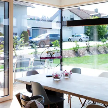 XXL Panoramafenster über Eck im Essbereich eines Bungalows in Fürstenzell. Gefertigt von Fenster-Spezialist Franz Renaltner (Passau), Meisterbetrieb für exklusiven Fensterbau seit 1926.