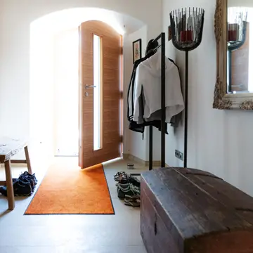 Lichtdurchfluteter Flur im Bauernhaus Fürstenzell-Scheuereck: Geöffnete Massivholz-Haustür mit Glaseinsatz von Schreinerei Franz Renaltner – meisterhafter Lichteinfall und Fensterhandwerk aus der Region Passau seit 1926.