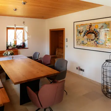 Großzügiger XXL-Esstisch vor maßgefertigten Holzfenstern mit tiefer Fensterbank im Bauernhaus Fürstenzell-Scheuereck – meisterhafter Lichteinfall durch Fensterbau-Lösungen der Schreinerei Franz Renaltner aus Passau seit 1926.