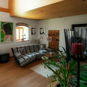 Großzügiges XXL-Wohnzimmer im Bauernhaus in Fürstenzell-Scheuereck: Maßgefertigte Holzfenster mit tiefer Fensterbank von Schreinerei Franz Renaltner kombiniert mit einem modernen Design-Sofa – Fensterhandwerk für Passau und München seit 1926.
