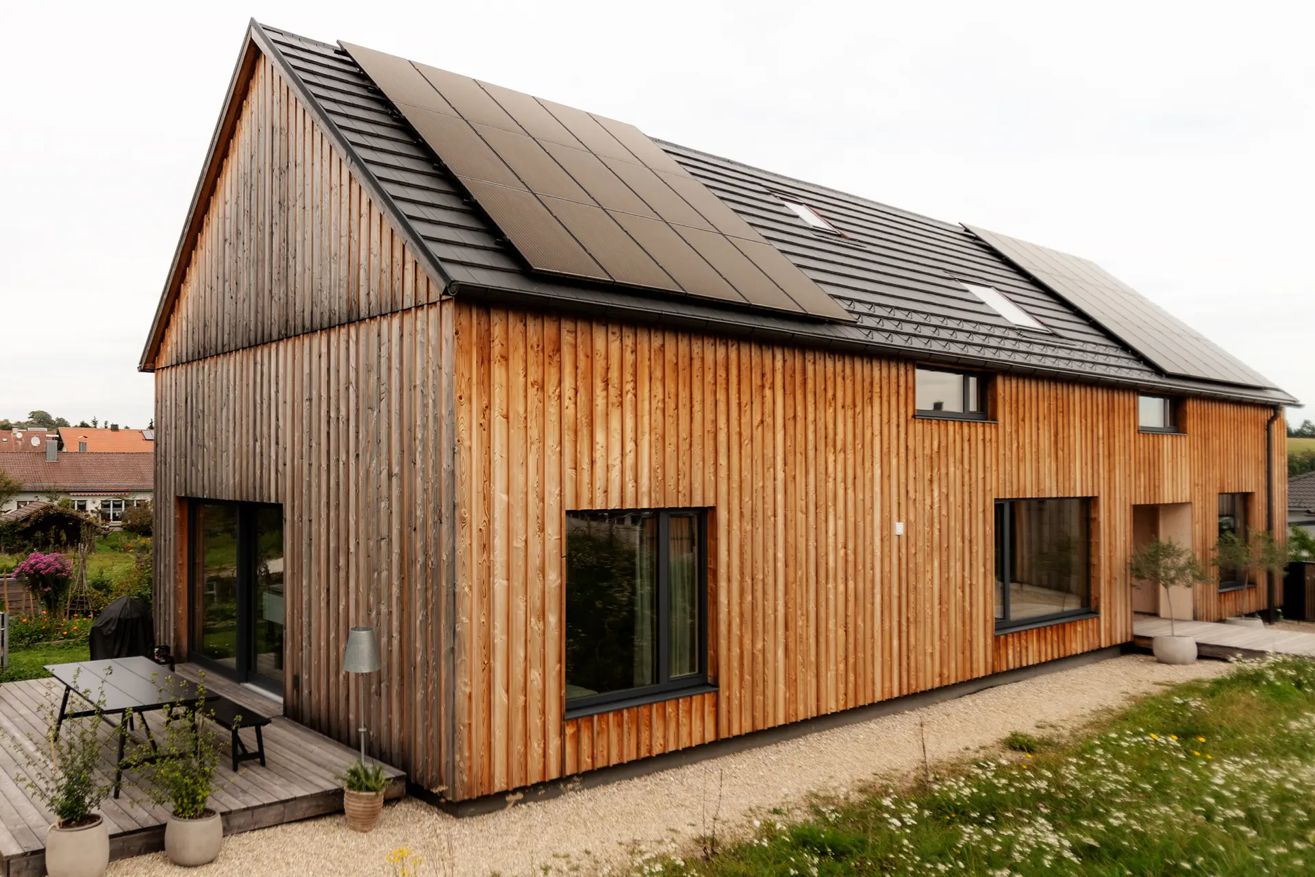 Lichtdurchflutetes Wohnzimmer im Haus 4.0: Große Holz-Alu-Panoramafenster in Fichte mit anthrazitgrauer Aluschale von Schreinerei Renaltner für maximalen Weitblick.
