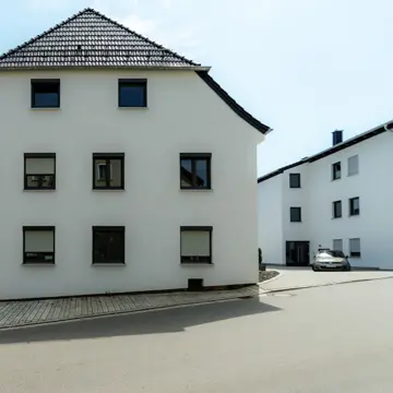 Referenzprojekt Neukirchen am Inn: Straßenseite der Wohnanlage (Alt- und Neubau). Fensterbau-Kompetenz von der Schreinerei Franz Renaltner – Qualität für Niederbayern, Oberösterreich und München.