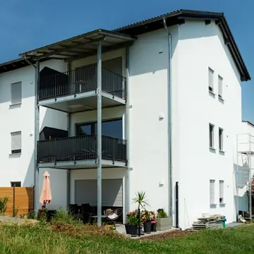 Neubau-Referenz Neukirchen am Inn: Ansicht der Wohnanlage aus der Natur mit modernen Fensterlösungen von der Schreinerei Franz Renaltner – Qualität im Fensterbau für Niederbayern und München.