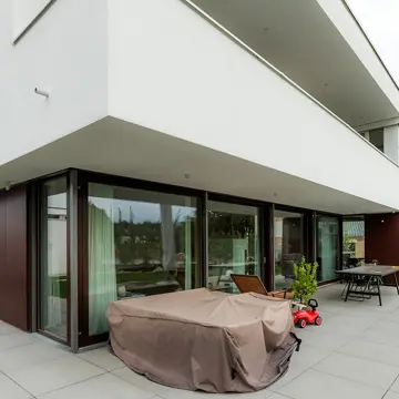 Moderne Fassadengestaltung mit einer 12m x 2,8m Panorama-Schiebetüre, Seitenverglasung und XXL-Balkonen. Maßgefertigte Fensterlösung der Schreinerei Renaltner (Spezialist seit 1926) für ein Wohnhaus in Passau.