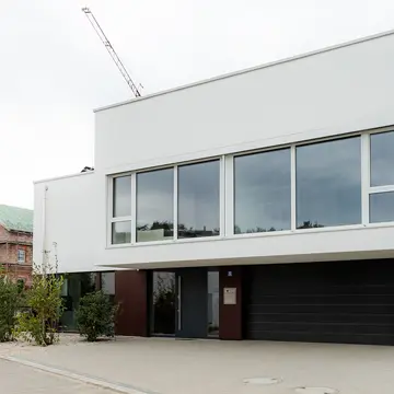 Vorderansicht mit Garage und Hauseingang eines Passauer Wohnhauses. Hochwertige Fensterelemente und Haustürlösungen der Schreinerei Renaltner (Spezialist seit 1926) für Niederbayern, Oberösterreich und München.