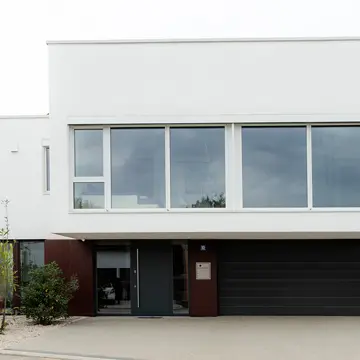 Gesamtansicht der Vorderseite eines Wohnhauses in Passau: Kombination aus Garage, Hauseingang und modernem Fensterbau. Handwerkliche Präzision der Schreinerei Renaltner (Spezialist seit 1926) für Niederbayern und München.