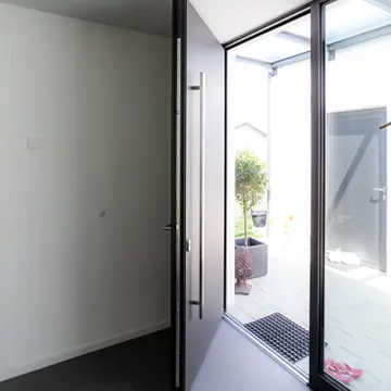 Innenansicht einer überextrabreiten, raumhohen Haustür mit integrierter Glasfront im modernen Bungalow – Sonderbau Schreinerei Renaltner