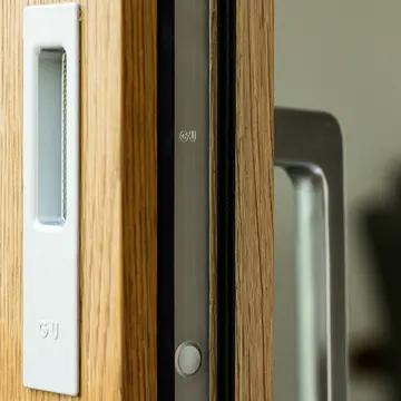 Detailaufnahme eines hochwertigen Griffs einer Hebeschiebetür in Eiche Natur mit Sicherheitsmechanik – Schreinerei Renaltner